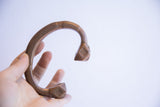 Antique African geometric copper cuff bracelet held in a hand to show its scale.