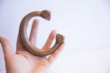 The antique African copper cuff shown in hand to illustrate its scale and form.