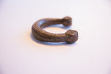 Angled view of an antique copper alloy bracelet showcasing its hand-carved geometric pattern.