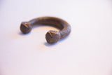 Faceted geometric terminal of an antique African cuff showing a hand-worked patina.