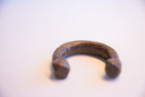Aged copper alloy patina and geometric engravings on the antique African bracelet.