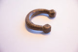Angled profile of an antique African copper cuff showing its curved form and faceted end.