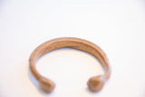 Incised craftsmanship and warm, time-softened patina on an antique African cuff.