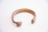 Profile view of the antique African bracelet showing its handmade form and patina.