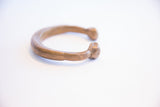 Angled profile of an antique snake cuff bracelet with a hand-carved head terminal.
