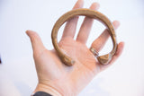 Antique African snake cuff bracelet held in hand, showing its scale and etched details.