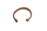 Antique African snake cuff bracelet with a warm metal patina and detailed etched patterns.