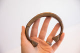 Antique bronze snake cuff held to show its handmade form and scale.
