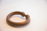 The antique African snake cuff's open design and warm, oxidized patina.