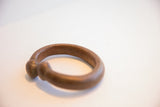 Aged patina and smooth, rounded ends of an antique African snake cuff.