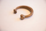 Angled view of the antique copper cuff bracelet's etched geometric terminals.