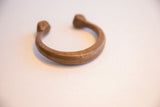 Aged copper patina and hand-etched patterns on an antique African snake bracelet.