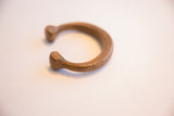 The sculptural form and aged copper patina of the snake cuff bracelet.