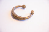 The sculptural C-shape of a collectible antique African cuff bracelet.