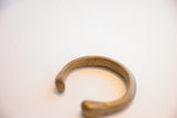 Close view of the fine etched details and aged brass patina on the antique cuff.