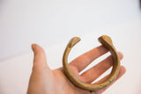 Antique snake cuff bracelet held in hand, showing its substantial form and aged patina.
