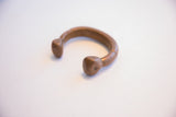 The solid, curved form of an antique African copper snake cuff bracelet.
