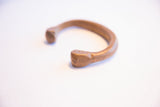 Hand-worked texture and unique shape of the antique snake cuff's terminal.