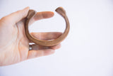 Antique African snake cuff bracelet held to show its size and curved form.