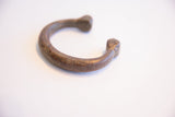 A side view of the antique African cuff, showing its curved form and textured patina.