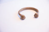 The smooth, aged patina on the open ends of an antique cuff.