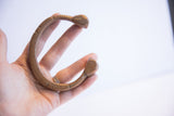 The curved form and scale of an antique African snake cuff bracelet.