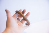 In-hand view of the antique African cuff showing its aged patina and substantial form.