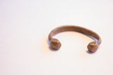 The open design of the antique African copper cuff with its shaped terminals.
