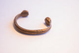Curved shape and etched details of an antique African copper cuff bracelet.