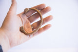 Handcrafted antique copper snake cuff bracelet held in hand to show its scale and form.