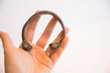 Antique African snake cuff bracelet held in hand to show its scale and aged patina.