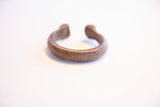 A side view of the antique African snake cuff's hand-etched surface.