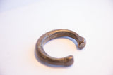 Angled profile of an antique African snake cuff showing etched details and an age-related crack.