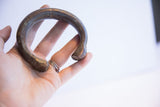 The solid, curved form and rich patina of the antique African snake bracelet.