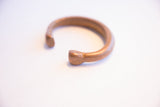 View of the antique copper cuff showing its open shape and hand-formed ends.