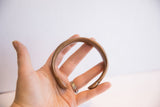 Antique copper snake cuff bracelet held in hand showing its scale and form.