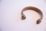 Angled view of the antique copper snake cuff showing its hand-worked texture and shape.