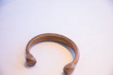 A detailed view of the hand-etched patterns on the antique African copper cuff.