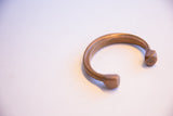 The simple, open C-shape of the antique African copper cuff bracelet.