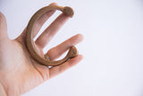 Antique African copper snake cuff bracelet held to show its wearable scale and form.