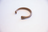 Angled profile of the antique African cuff highlighting its open, rounded ends.