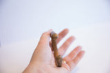 The rounded, open ends of the antique snake cuff bracelet shown held in hand.