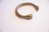 Detail of the antique bronze bracelet's end, highlighting simple hand-worked markings.