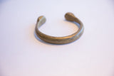Antique African bronze cuff bracelet showing its simple C-shape and open ends.