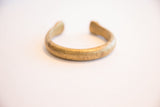 The open C-shape and aged surface patina of the antique bronze snake cuff.