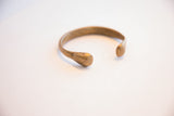 Profile view of the antique bronze snake cuff bracelet showing its open form and warm patina.