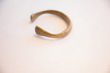 Angled view of the antique bronze cuff's open C-shape and smooth ends.