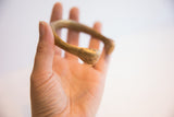The smooth, curved profile and aged patina of an African bronze cuff bracelet.