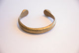 Side profile of the antique African bronze bracelet highlighting its open cuff and aged patina.