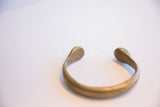 The smooth, rounded open ends of the antique African bronze cuff.